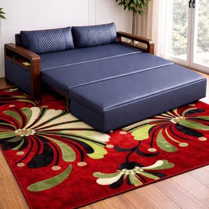 Könnte beinhalten: Ein marineblaues Schlafsofa mit Holzarmlehnen und einer gemusterten Kopfstütze. Das Sofa ist ausgezogen und zeigt ein Bett. Es steht auf einem roten Teppich mit floralem Design. Der Teppich liegt auf einem Holzboden.