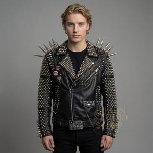 May include: Black leather jacket heavily embellished with silver studs and spikes. The jacket features a classic asymmetrical zipper design, multiple pockets, and a studded belt. Patches and pins adorn the left chest area. A bold statement piece.