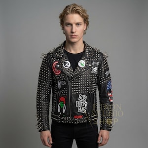 May include: Black leather jacket covered in silver studs and spikes. The jacket features multiple patches with various designs and the text "SUB HUMANS". A classic biker jacket style.