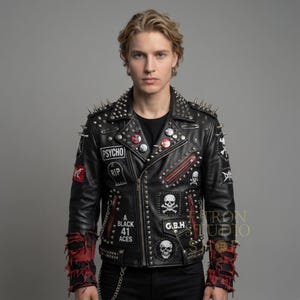 May include: Black leather jacket with silver spikes on the shoulders and collar. The jacket features multiple patches, including the word "PSYCHO" and skull designs. Red accents are visible on the sleeves and zipper details. The jacket has a classic biker style.