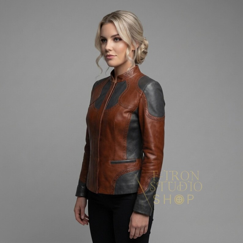 Three-quarter view of a fashion-forward women's leather jacket in cognac and charcoal gray.