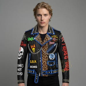 以下が含まれることがあります： 青と銀のアクセントが施された黒い革のジャケット。パッチとスカルグラフィックが特徴です。ジャケットにはヒョウ柄のパネル、シルバースタッド、チェーンが付いています。「Misfit」、「D.O.A.」、「G.B.H.」、「Discharge」、「Unks Not Dead」、「Fear」などのテキストが含まれています。