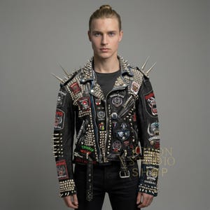 May include: Black leather jacket adorned with silver studs, spikes, and patches. The jacket features a belted waist, multiple zippers, and patches with skull and band logos. The sleeves and shoulders are heavily embellished with metal studs and spikes.