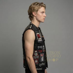 Profile view of men's custom leather vest showcasing pyramid studs and various patches.