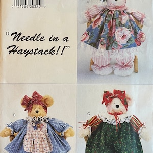 May include: A sewing pattern for a teddy bear with three different outfit options. The pattern is called "Needle in a Haystack!" and is for one size. The outfits include a floral dress, a blue dress with an apron, and green overalls.