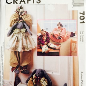 May include: A sewing pattern for making three stuffed bunny doorstops. The pattern includes instructions for making a bunny with a dress, a bunny with pants, and a bunny with a skirt. The pattern is called "One Envelope - Une Pochette" and is by/par Faye Wine.