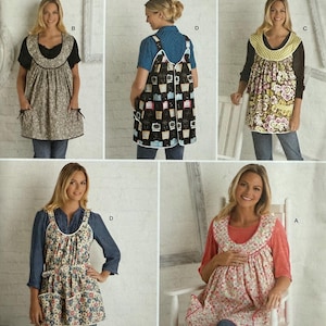 May include: Simplicity sewing pattern 2390 featuring apron designs. The aprons have various floral and patterned fabrics, with different necklines and pocket styles. The pattern includes sizes A-S-L and is suitable for home sewing projects.