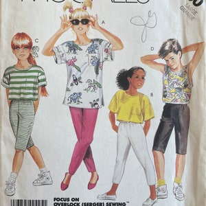 May include: A sewing pattern for children's clothing. The pattern includes instructions for a striped shirt, a white shirt with a pocket, a patterned shirt, and a pair of shorts. The pattern is for size large.