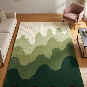 May include: A rectangular rug with a wavy, layered design in shades of green and off-white. The rug's pattern resembles rolling hills or mountains, creating a textured, three-dimensional effect. The rug is placed on a wooden floor.