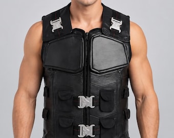 May include: A black leather vest featuring a central zipper closure, two silver-toned metal buckles on the front, and two additional buckles on the shoulder straps. The vest includes padded chest panels and multiple small pockets with flaps.