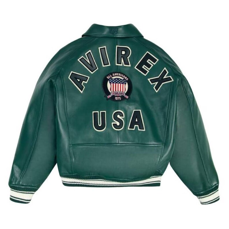 May include: A dark green leather jacket with the word "AVIREX" arched across the upper back in white lettering. Below the lettering is a patch with the words "ALL AMERICANS ESTABLISHED 1975" and a USA flag design. The word "USA" is below the patch.