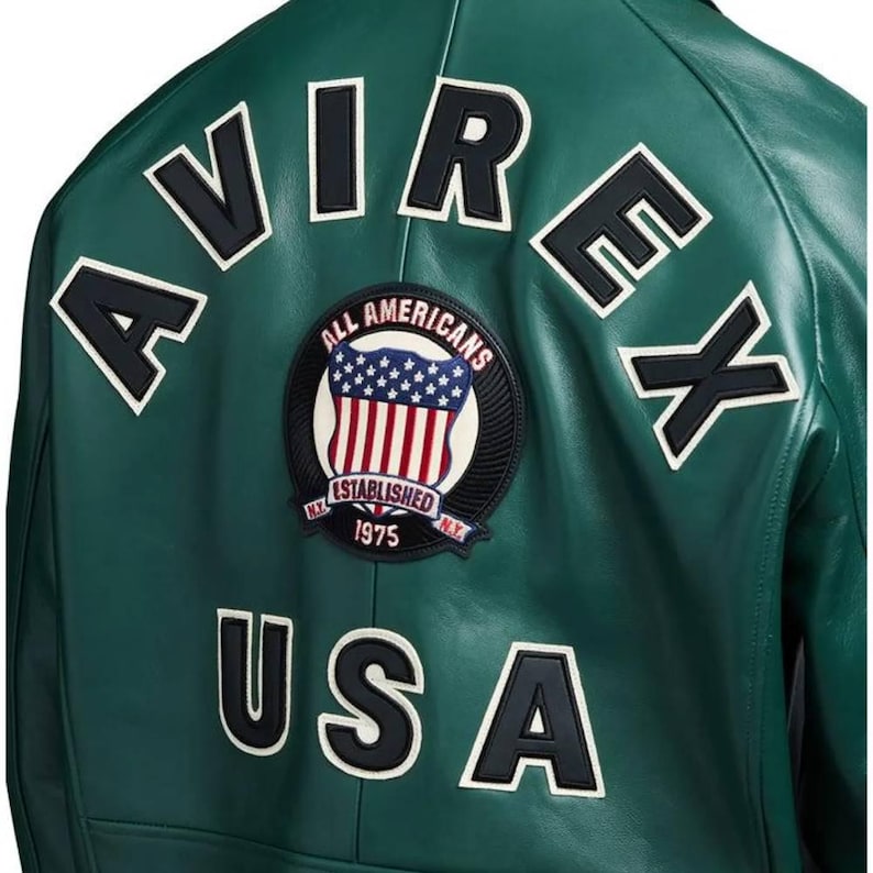 May include: A green leather jacket with white-outlined black lettering spelling "AVIREX" and "USA". A circular patch features the American flag and the words "ALL AMERICANS ESTABLISHED 1975 N.Y."