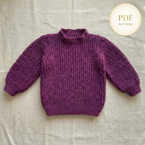 May include: A knitted purple sweater with a ribbed texture and a high neckline. The long sleeves have a slightly puffed design. The image includes a circular graphic with the text "PDF PATTERN".
