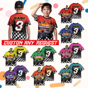 May include: A collection of colorful t-shirts featuring monster truck graphics, flames, and the number 3. The shirts are available in various colors, including red, blue, green, pink, purple, orange, and teal, with a checkered pattern.