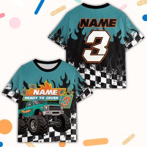 May include: Two short-sleeved t-shirts with a teal and black design. One shirt features a monster truck graphic with the text "READY TO CRUSH" and the number 3. The other shirt has the number 3 and the word "NAME".