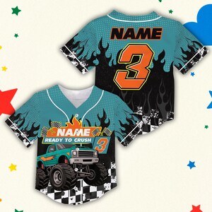以下が含まれることがあります： 2つの野球スタイルのジャージ。1つは、モンスター・トラックのグラフィックと「NAME READY TO CRUSH 3」のテキストが入ったティール色です。もう1つは、オレンジ色の数字3と「NAME」のテキストが入った黒色です。どちらも炎のデザインと市松模様があります。