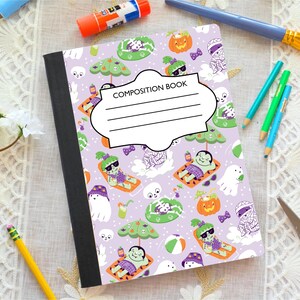 May include: A composition book with a purple cover featuring a Halloween-themed pattern. The pattern includes cartoon ghosts, pumpkins, and sunbathing monsters. The cover has a white label that reads "COMPOSITION BOOK" with lines for writing.