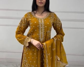 May include: Mustard yellow embroidered salwar kameez set. The long-sleeved tunic and matching trousers are adorned with intricate beadwork and embroidery. A sheer dupatta completes the ensemble. Suitable for special occasions.