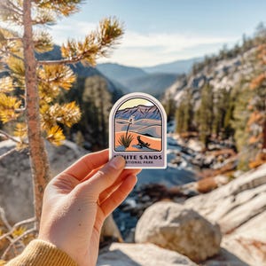 a person holding up a sticker that says hike sands