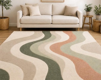Pode incluir: Um tapete retangular com um padrão ondulado em tons de bege, verde e pêssego. O tapete está colocado sobre um chão de madeira em frente a um sofá bege. O design do tapete adiciona um toque retro ao ambiente.