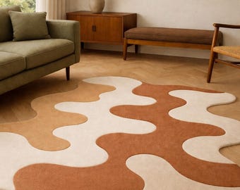 Pode incluir: Um tapete moderno com um design abstrato. O tapete apresenta um padrão ondulado em tons de castanho, bege e creme. O tapete é colocado sobre um chão de madeira e adiciona um toque de estilo contemporâneo à divisão.