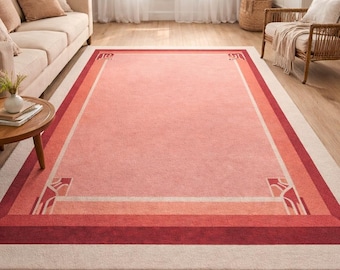 Pode incluir: Um tapete retangular com um centro rosa suave, ladeado por faixas de rosa claro, pêssego e vermelho escuro. O tapete apresenta desenhos decorativos nos cantos e uma borda externa creme. Este tapete é adequado para salas de estar.