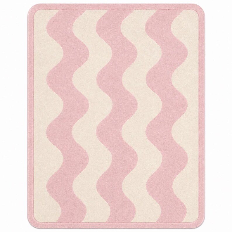 May include: A rectangular area rug featuring a repeating vertical wavy pattern in soft pink and cream colors. The rug has rounded corners and is finished with a solid pink border that frames the entire design, creating a clean and uniform edge.
