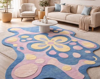 Pode incluir: Um tapete abstrato com uma forma distinta, apresentando uma base azul com padrões florais e de pontos rosa e amarelos. O tapete é colocado sobre um tapete de cor clara numa sala de estar. Dimensões aproximadas: 200 cm x 300 cm.