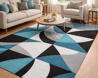 Pode incluir: Um tapete geométrico com um design moderno. O tapete apresenta um padrão de triângulos e formas curvas em tons de azul, cinza, preto e branco. O tapete está colocado sobre um chão de madeira numa sala de estar.
