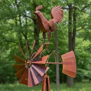 May include: A rustic metal rooster weathervane atop a windmill. The rooster is in a crowing pose, with detailed feathers and a comb. The windmill blades and frame are made of the same weathered metal, creating a cohesive, outdoor decorative piece.