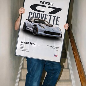 May include: A framed poster featuring a light blue Chevrolet Corvette C7 Grand Sport. The poster includes the car's specifications, such as the V8 6.2L engine and 460 HP. The text "Chevrolet Corvette C7 Grand Sport 2019" is also visible.