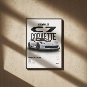 May include: Framed poster featuring a white Chevrolet C7 Corvette Grand Sport. The poster includes the car's name, specifications, and the American flag. The car is depicted in a studio setting, with the text "Chevrolet C7 Corvette" at the top.
