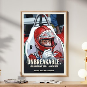 May include: A framed print showing a racing driver in a red helmet, with the word "UNBREAKABLE" and text about Nürburgring 1976 > Monza 1976. The artwork is displayed on a wooden cabinet.
