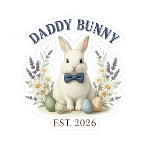 Peut inclure: Un autocollant avec un lapin blanc portant un nœud papillon bleu, entouré de fleurs et d'œufs de Pâques. Le texte "DADDY BUNNY" est au-dessus du lapin, avec "EST. 2026" en dessous. Le design a un effet aquarelle.