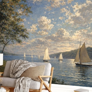 Op de afbeelding: Een schilderij dat een zeegezicht weergeeft met zeilboten op het water onder een bewolkte hemel. Het kunstwerk toont een bank met een deken en kussen op de voorgrond en een lamp aan de linkerkant.