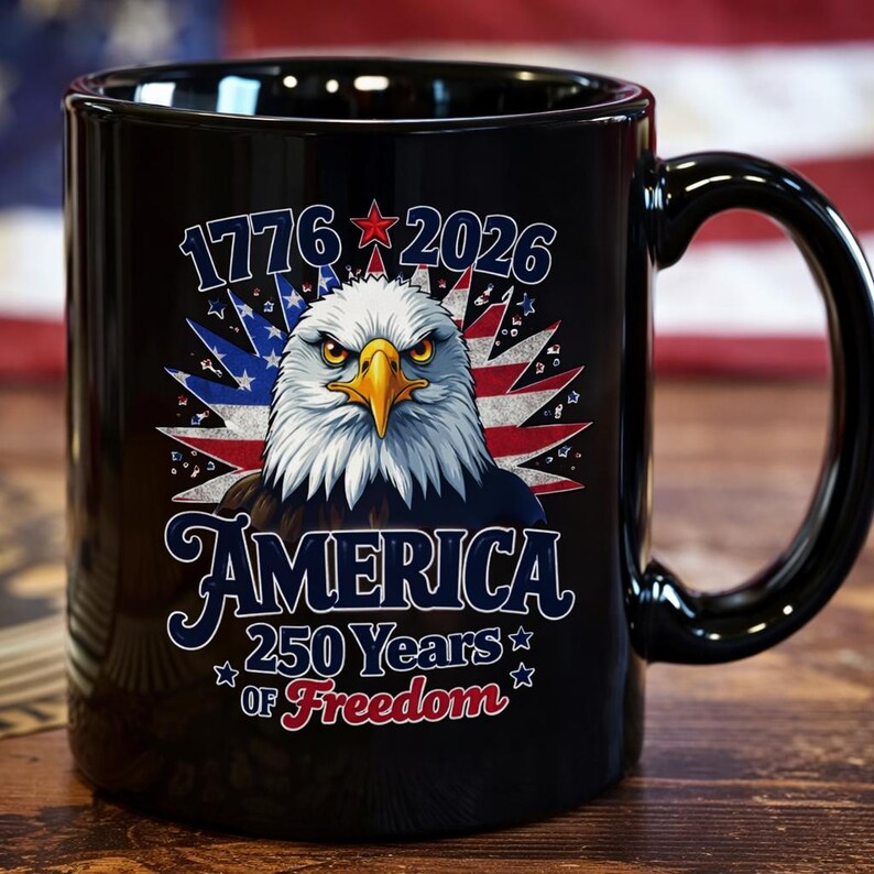 May include: Black ceramic mug featuring a patriotic design. The design includes a detailed illustration of an American bald eagle, the text "1776 2026 AMERICA 250 Years of Freedom", and a background of the American flag.