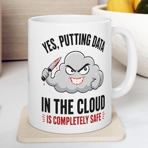 May include: A white ceramic mug featuring a cartoon grey cloud character with an angry expression, holding a bloody knife. The text reads: YES, PUTTING DATA IN THE CLOUD IS COMPLETELY SAFE. The mug has a standard handle and a smooth, glossy finish.