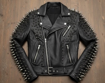 Può includere: Giacca in pelle nera con borchie argentate su spalle e maniche. La giacca presenta un classico stile biker con chiusura a zip, tasche multiple e cintura in vita.