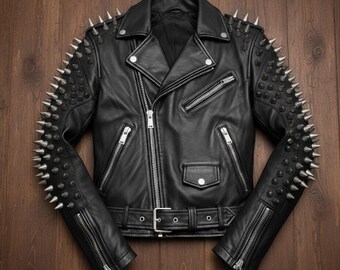 Può includere: Giacca in pelle nera con borchie argentate su spalle e maniche. La giacca presenta un classico stile biker con colletto a revers, chiusura asimmetrica con zip e cintura in vita. Su una superficie di legno.