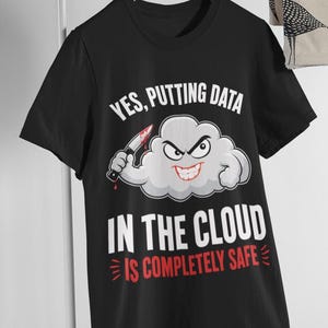 Puede incluir: Una camiseta negra con un gráfico de una nube de dibujos animados con cara de enfado que sostiene un cuchillo. El texto dice: YES, PUTTING DATA IN THE CLOUD IS COMPLETELY SAFE. La nube es gris claro con contornos oscuros y el texto es blanco y rojo.