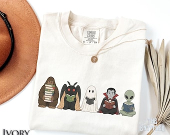 Cartoon Cryptid Reading T-Shirt, Spooky Reading Top, Halloween Bigfoot Mothman Ghost Vampire Alien Shirt, Cryptid Tee, Cozy Book Lover Shirt