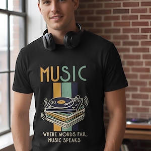 May include: Black t-shirt with the word "MUSIC" in yellow and green, and a graphic of a record player on top of a stack of records. The text "WHERE WORDS FAIL, MUSIC SPEAKS" is below the graphic.
