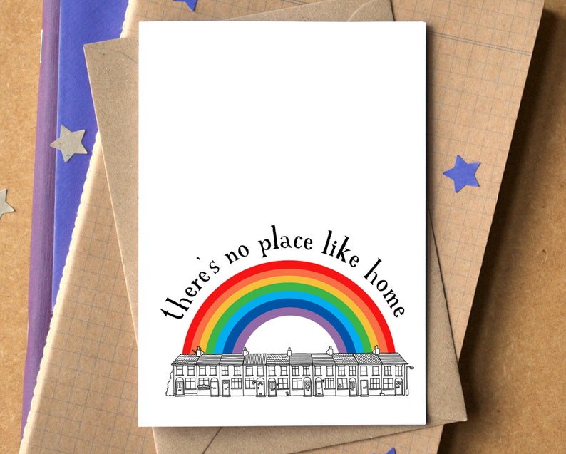K&ouml;nnte beinhalten: Eine Gru&szlig;karte mit einem Regenbogen &uuml;ber einer Reihe von H&auml;usern und dem Text "Es gibt keinen Ort wie zu Hause".