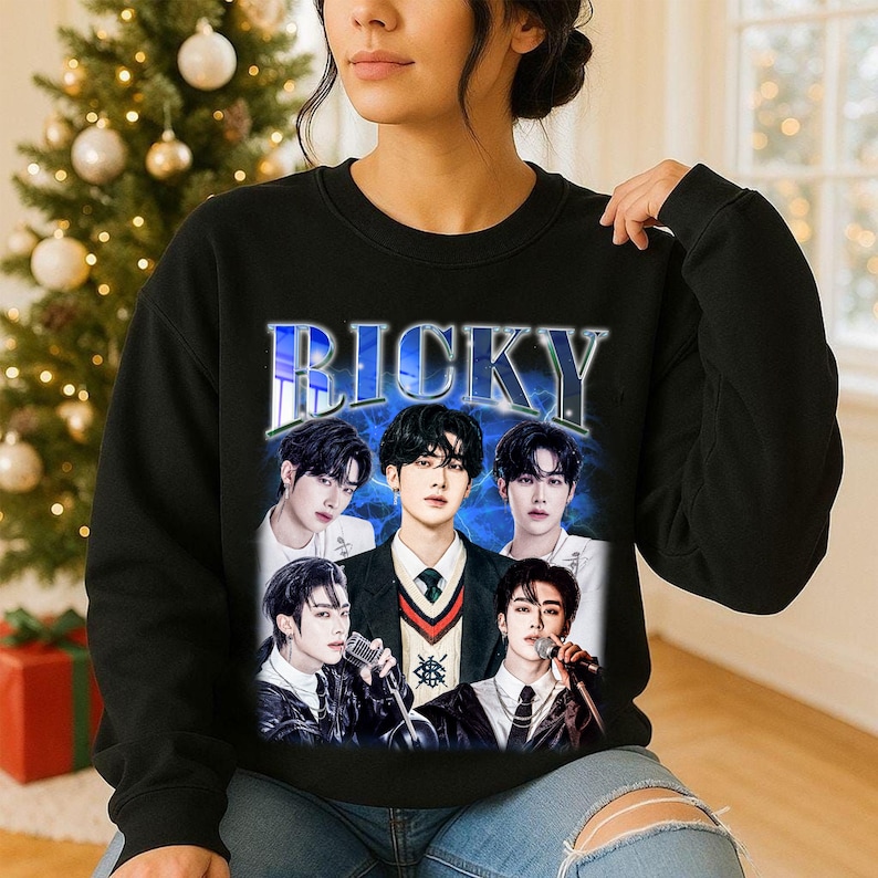 May include: Black sweatshirt featuring a graphic of five young men with the name "RICKY" in a blue and white retro font. The image has a vintage aesthetic, with the men in various poses.