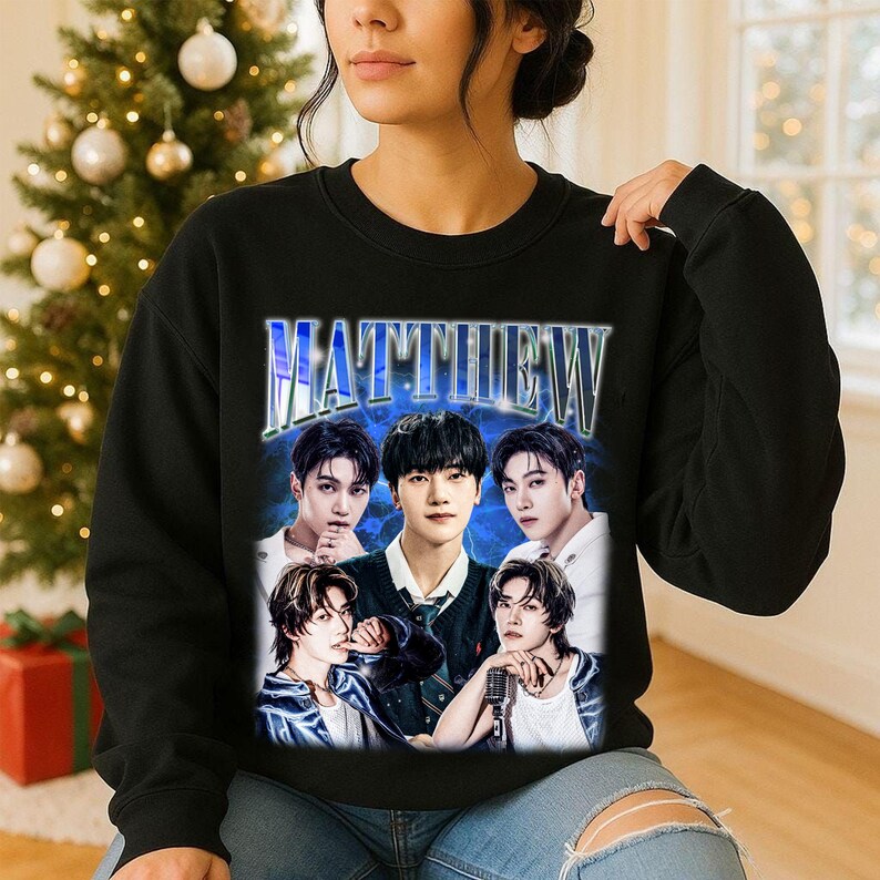 May include: Black sweatshirt featuring a graphic of five people with the name "MATTHEW" in a blue, stylized font. The image has a vintage aesthetic, with a blue background and the people in the image are wearing various outfits.