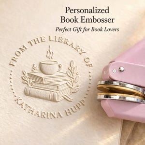 May include: A personalized book embosser with a light pink handle and a circular embossed design. The design includes a stack of books, a coffee cup, and the text "From the Library of Katharina Hupp."