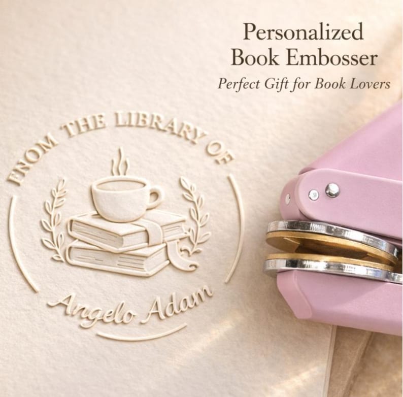 May include: A personalized book embosser with a light pink handle and a circular die. The embossed design includes a stack of books, a coffee cup, and the text "From the Library of Angelo Adam". The text "Personalized Book Embosser" is also visible.