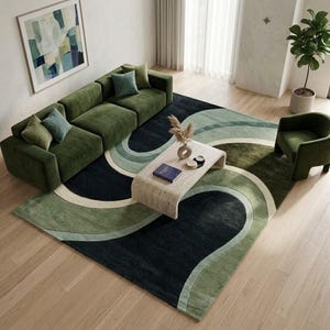 May include: A large rectangular area rug featuring a sweeping wave pattern in shades of dark charcoal, sage green, and cream. The rug is positioned under a green velvet sectional sofa, a curved wooden coffee table, and a matching green armchair.