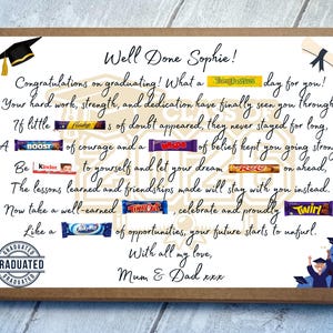 May include: A rectangular cardboard gift box featuring a graduation-themed message for Sophie. The text includes candy bars integrated into the sentences, such as Tangfastics, Flake, Boost, Wispa, Kinder, Roo, TimeOut, Twirl, and MilkyWay, with illustrations of a cap and diploma.