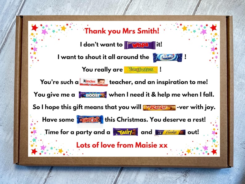 May include: A brown cardboard gift box featuring a white label with colorful star confetti. The label contains a personalized message for a teacher, incorporating various candy bar brand names into the text, signed by Maisie at the bottom.